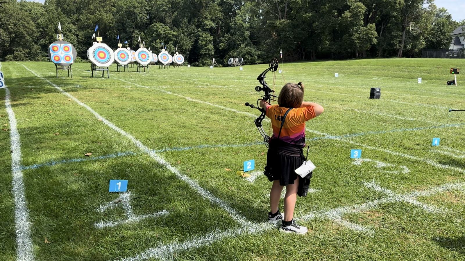 Young archers shooting at target faces on the outdoor field range